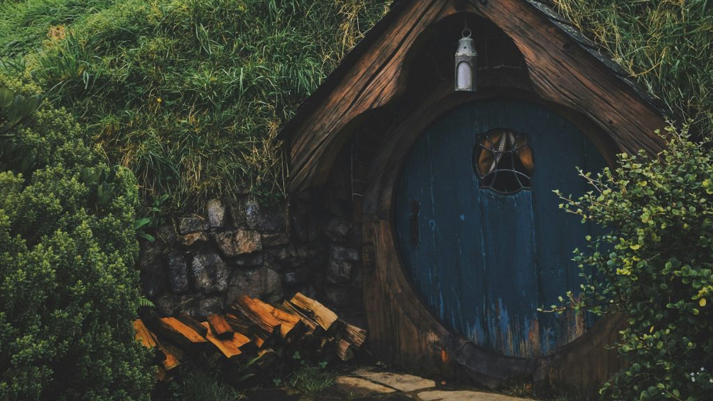 A hobbit hole looking door in a mountainside.